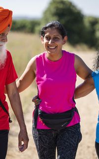 A group of two women and a man take a walk in the park.