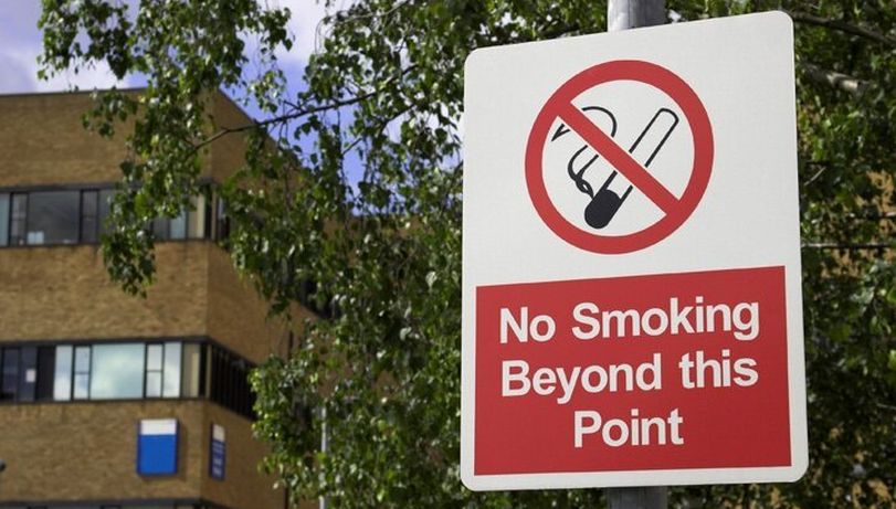 A sign outside a building reading "no smoking beyond this point"