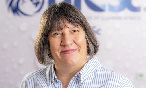 Denise Hanson, a white woman with short brown hair smiles at the camera