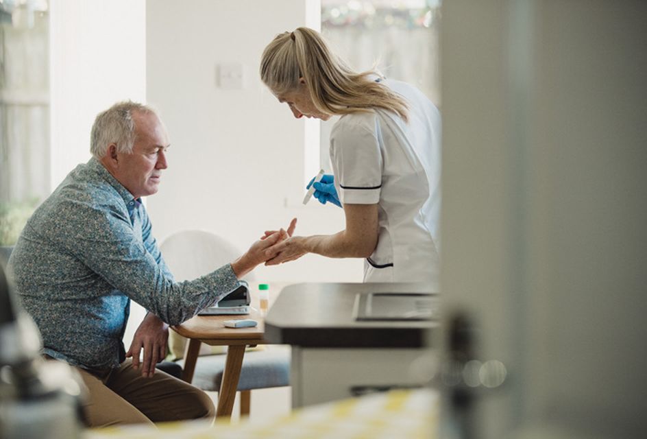 A healthcare worker treating an older man