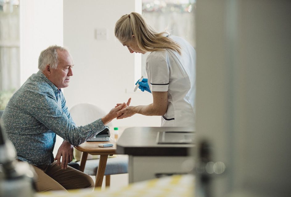 A healthcare worker treating an older man