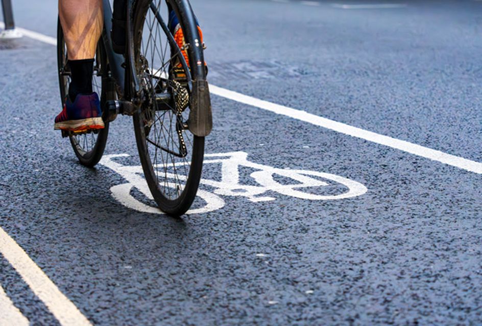 A close-up of a bike being ridden along a cycle lane.
